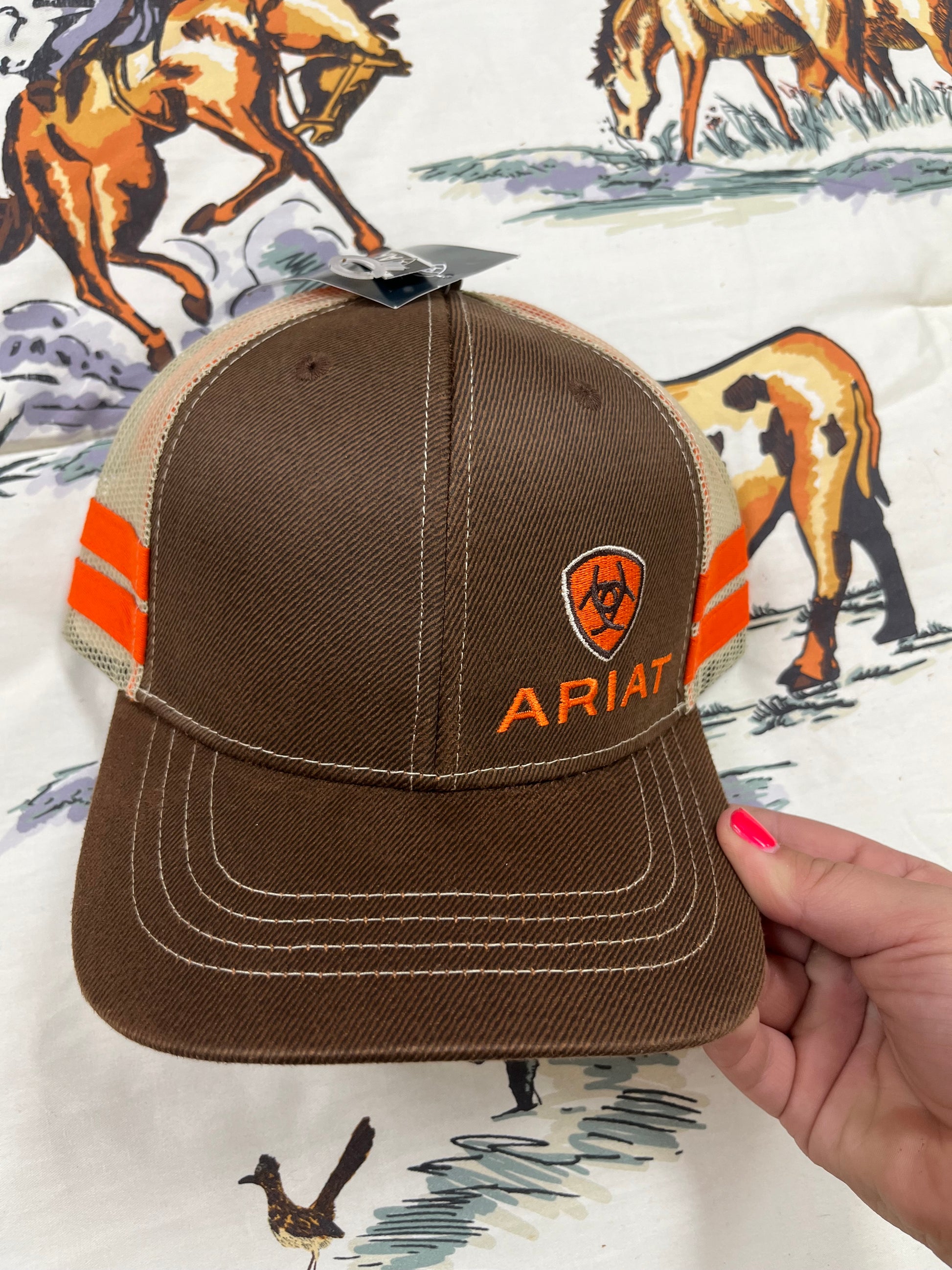 Ariat-Offset logo on an orange striped/brown cap - Wines'Designs