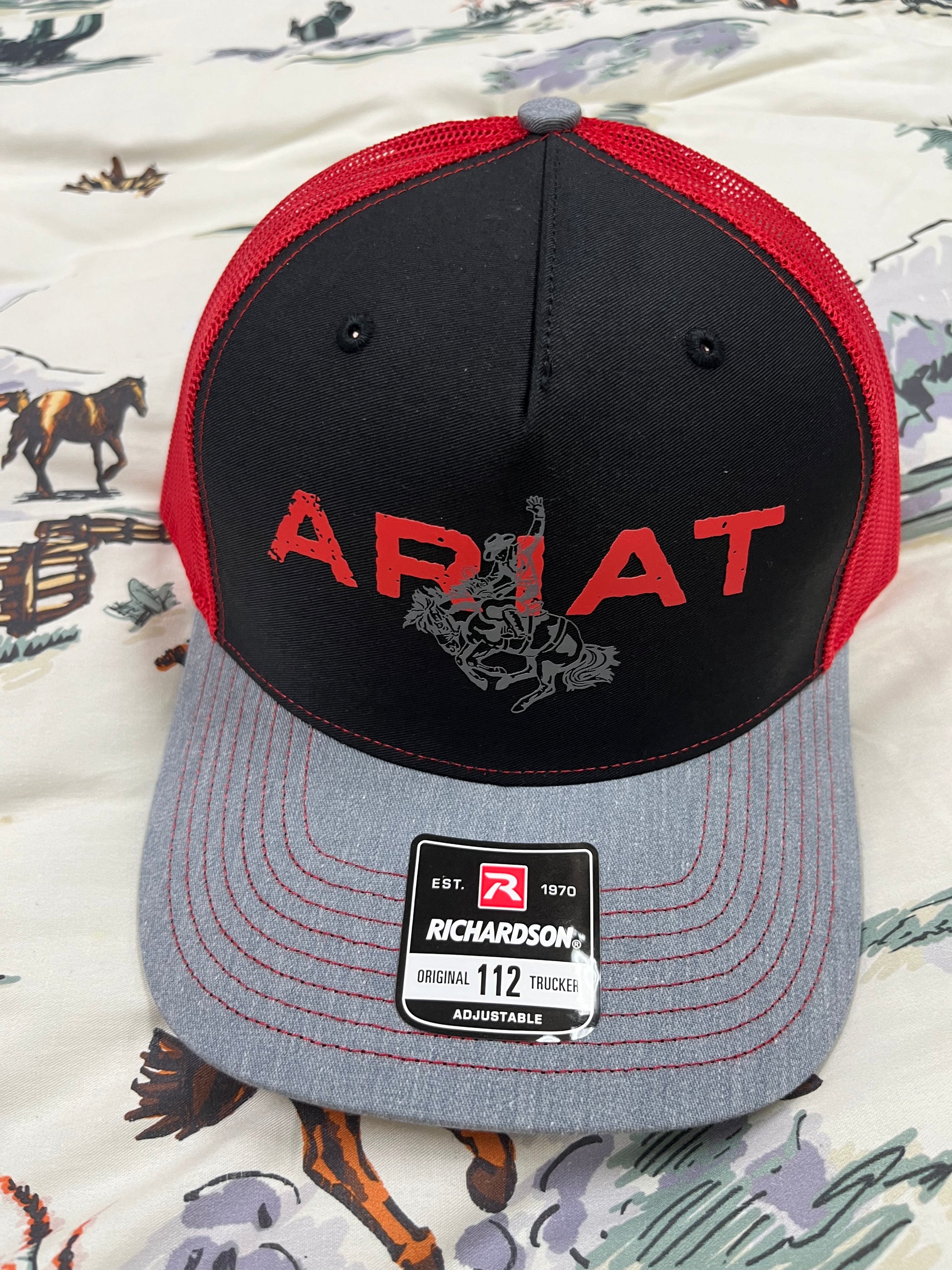 Ariat bronc on a black/grey/red cap - Wines'Designs